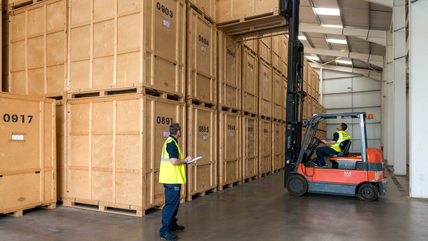 Kerr’s warehouse team managing stacked wooden storage vaults at Edinburgh facility